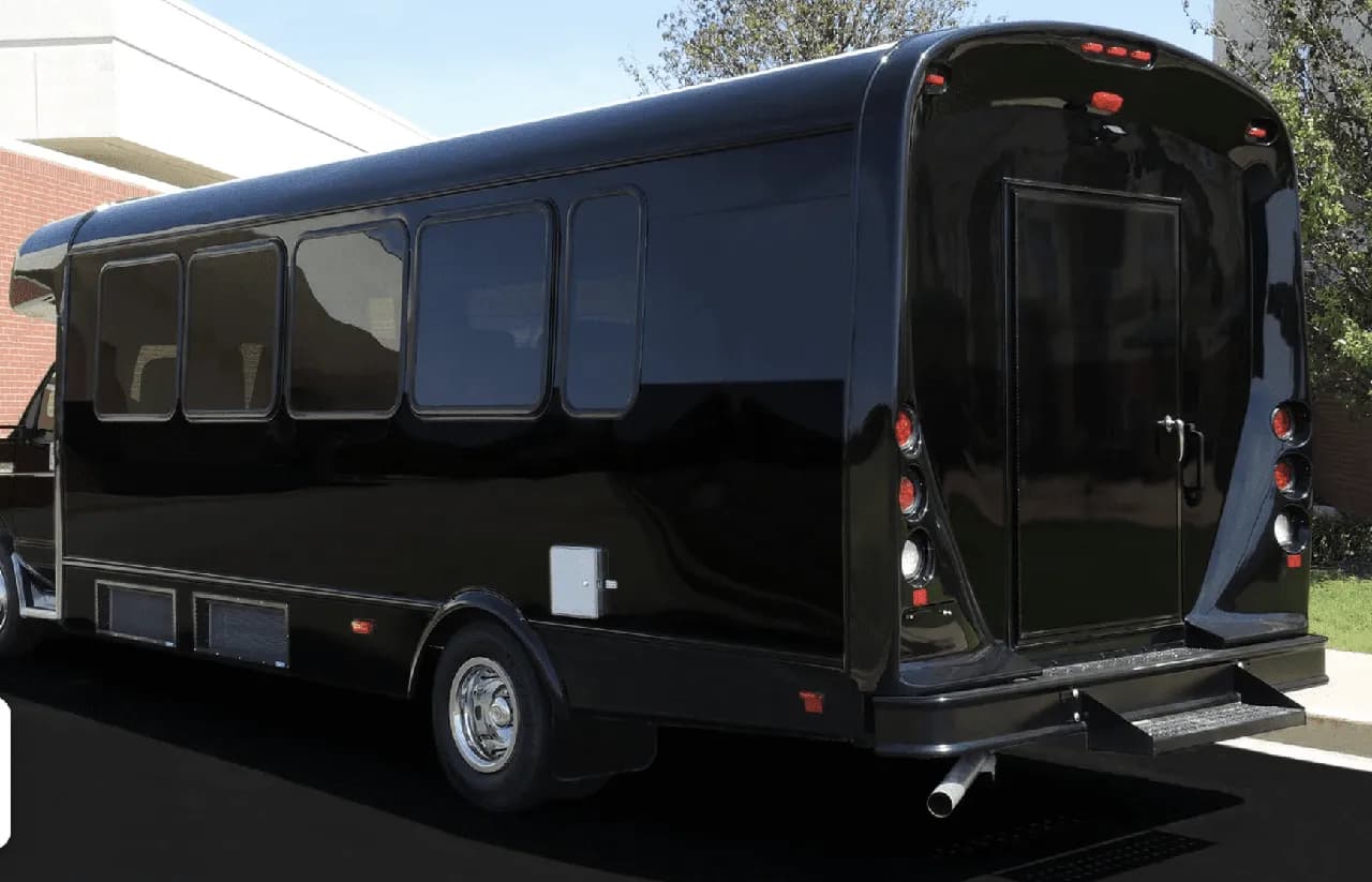 Black 22 Passenger Limo Coach exterior with tinted windows for party bus rental Black 22 Passenger Limo Coach exterior with tinted windows for party bus rental