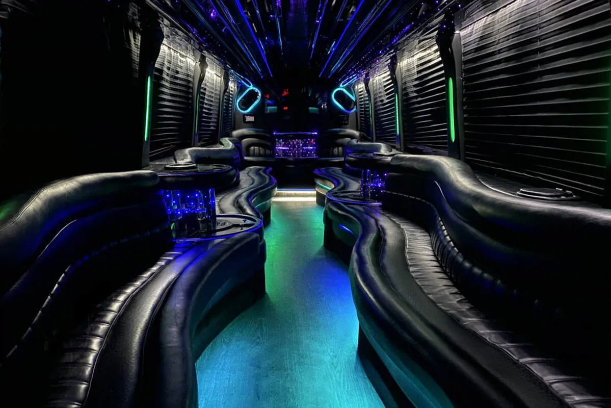 Entertainment Coach interior with perimeter lounge seating, window shades and LED accent lighting for party bus rental