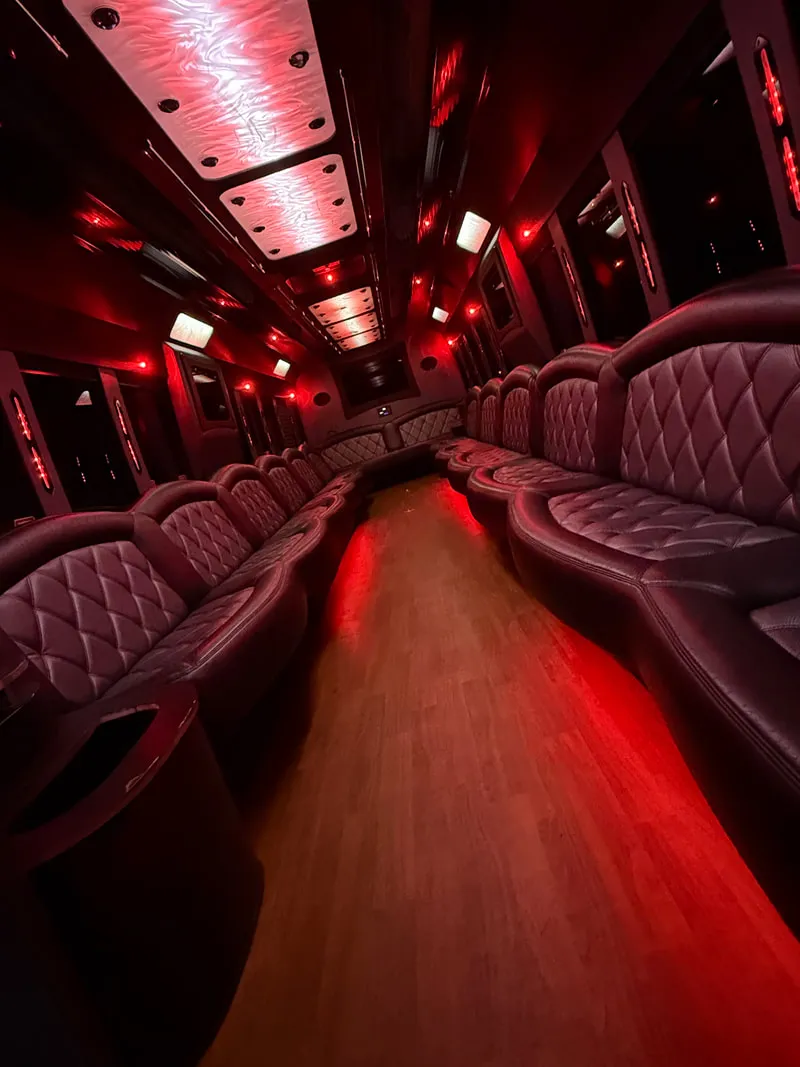 Freightliner Party Bus interior with perimeter lounge seating, LED ceiling lighting and wood-look flooring, photo 9 for party bus rental in North Attleboro, MA