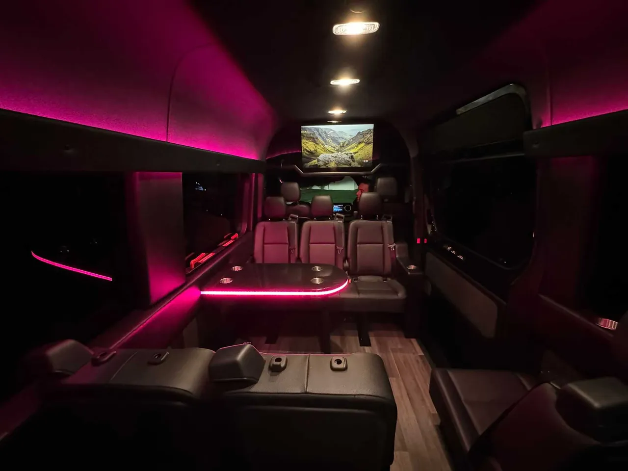 Mercedes Executive Sprinter Mercedes Executive Sprinter interior with passenger tables, LED accent lighting and wood-look flooring for party bus rental