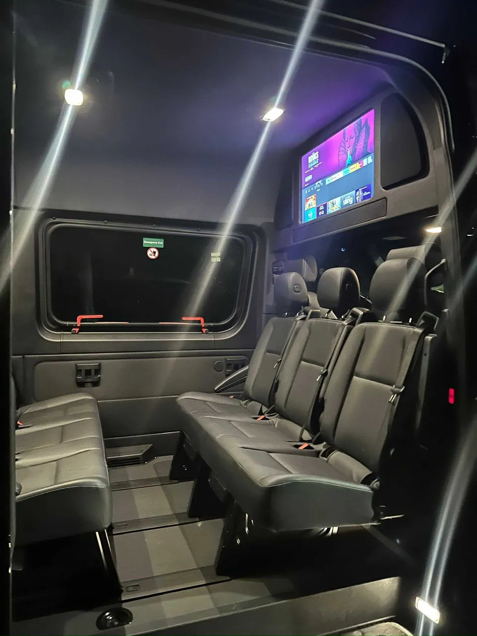 Mercedes Limo Sprinter interior with TV screens and passenger seat belts for party bus rental in Pinetta, FL