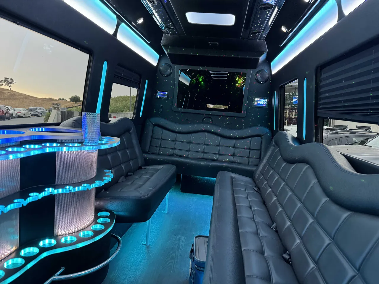 Mercedes-Benz Party Bus interior with perimeter lounge seating, window shades and LED accent lighting for prom car rental in Burson, CA