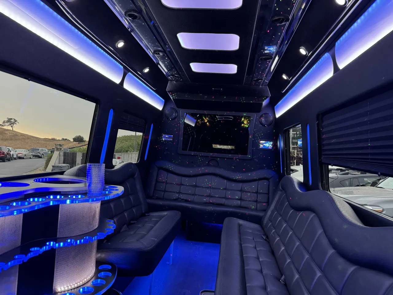 Mercedes-Benz Party Bus interior with perimeter lounge seating, window shades and LED accent lighting, photo 5 for prom car rental in Burson, CA