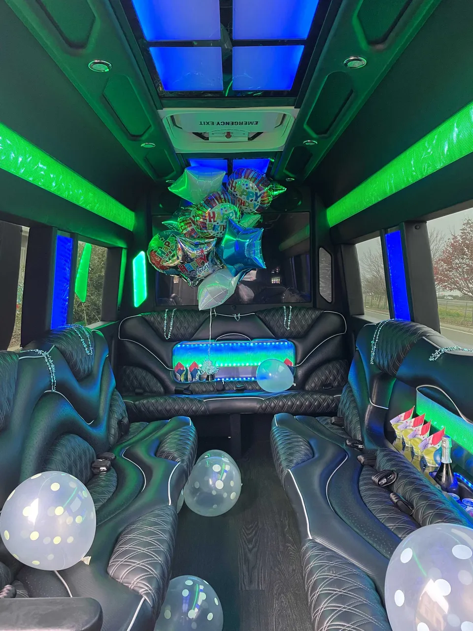 Mercedes Sprinter Limo interior with perimeter lounge seating, LED accent lighting and LED ceiling lighting for party bus rental in Burson, CA