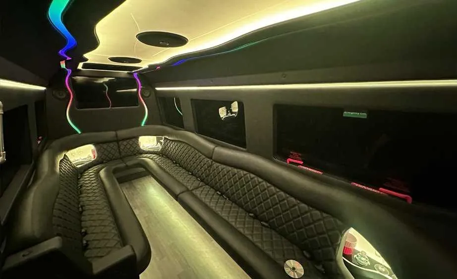Mercedes-Benz Sprinter Limousine interior with perimeter lounge seating, LED accent lighting and bar area for limo rental in Burson, CA