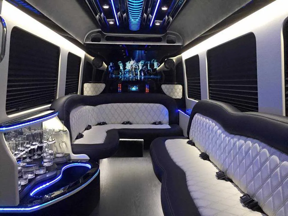 Mercedes-Benz Sprinter Limousine interior with perimeter lounge seating, sofa-style seating and window shades for party bus rental in Plainville, MA