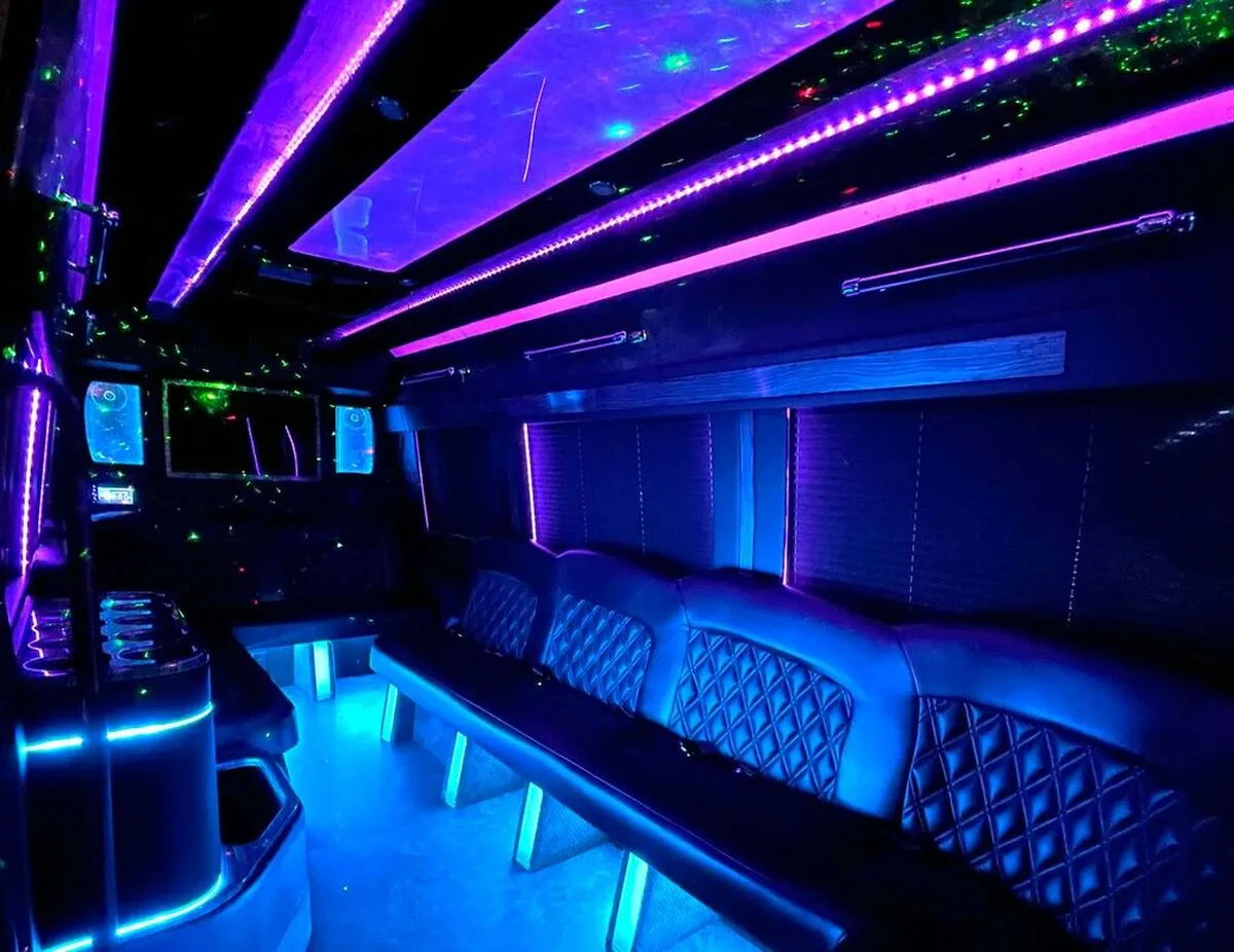 Mercedes Sprinter XL interior with perimeter lounge seating, window shades and LED accent lighting for party bus rental