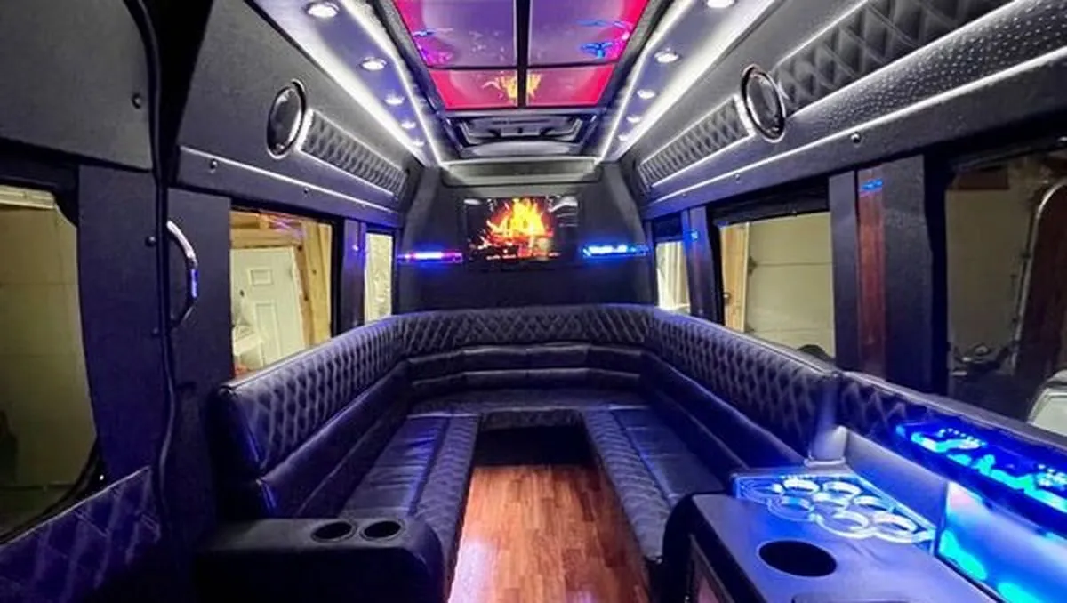 Mercedes Sprinter XL interior with perimeter lounge seating, sofa-style seating and cup holders for party bus rental
