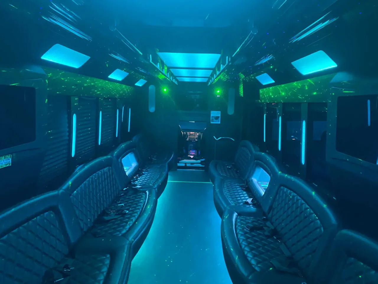 25 Passenger Party Bus interior with perimeter lounge seating, LED accent lighting and LED ceiling lighting, photo 2 for party bus rental in Ozone Park, NY