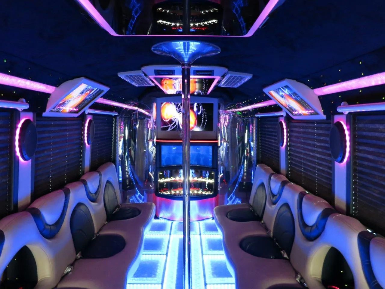 26 Passenger Party Bus interior with perimeter lounge seating, window shades and LED accent lighting for party bus rental in Burson, CA