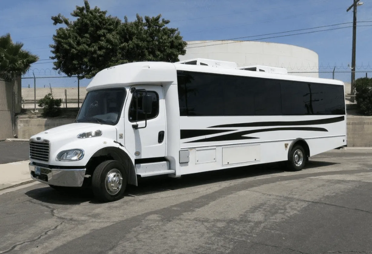 White 26 Passenger Party Bus exterior with tinted windows for party bus rental in Burson, CA
