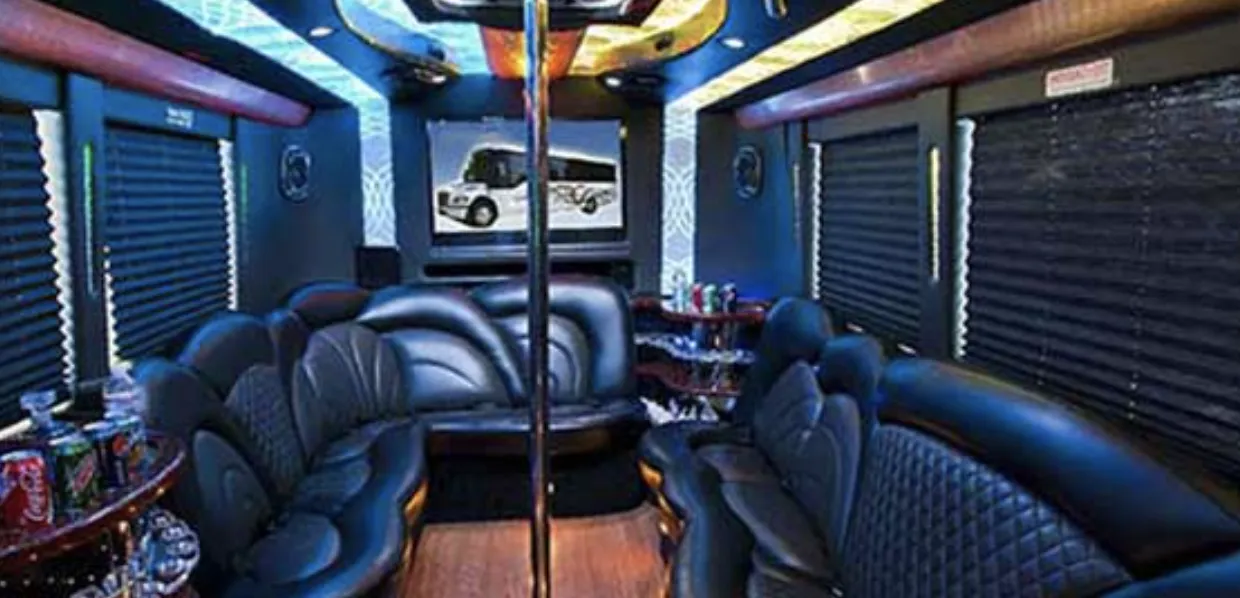 24 Passenger Party Bus interior with perimeter lounge seating, sofa-style seating and window shades for party bus rental in Burbank, CA