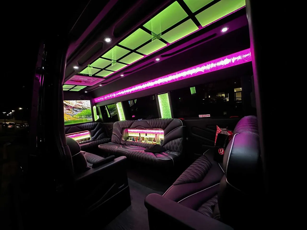13 Passenger Sprinter Limo interior with sofa-style seating, captain's chairs and LED accent lighting for party bus rental